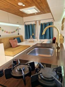 厄尔梅达诺Static Camper in front of the Sea的带水槽和沙发的厨房