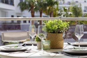 einen Tisch mit Gläsern und Tellern und eine Pflanze darauf in der Unterkunft La casa de Paola en Aguacate Beach in Motril