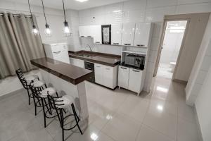 uma cozinha com electrodomésticos brancos e bancadas pretas em ADTUR Flats CTC - Condomínio Saphire ou Center Caldas em Caldas Novas