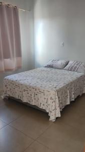 a bed with a blanket on it in a room at Apartamento com Vista Panorâmica in São Gabriel