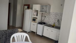 a kitchen with a white refrigerator and a microwave at Apartamento com Vista Panorâmica in São Gabriel