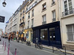 a group of people riding bikes on a city street at Appartement design au cœur du Marais in Paris