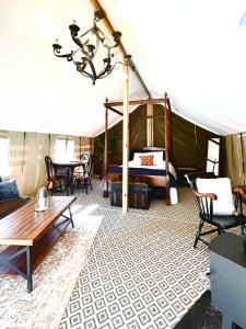 a room with a tent with a table and chairs at Outdoor Adventure Retreats - Wilderness Cove Campground in Saluda