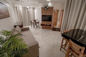 uma sala de estar com um sofá e uma TV em ADTUR Flats CTC - Condomínio Saphire ou Center Caldas em Caldas Novas