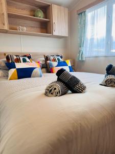 a bedroom with two beds with pillows on them at Little Cha-Am Caravan Hire at Silver Sands in Lossiemouth +66 photos