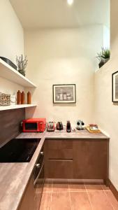 eine Küche mit einer Arbeitsplatte und einer roten Mikrowelle in der Unterkunft Residenza Palazzo Gherardi in Parma