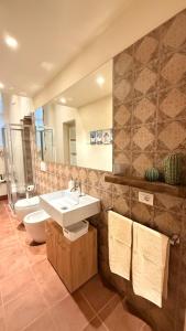 ein Badezimmer mit Waschbecken, Toilette und Spiegel in der Unterkunft Residenza Palazzo Gherardi in Parma + 30 Fotos