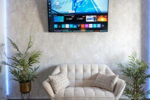 Una sala de estar con un sofá blanco y un televisor de pantalla plana. en Apartament Magic Home Iris Reception 24h, en Benalmádena