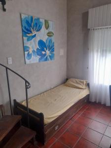 a bed in a room with a painting on the wall at Quinta Las Violetas in Mercedes +10 photos