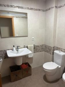 a bathroom with a toilet and a sink and a mirror at Apartamento con vistas Panticosa in Panticosa +9 photos