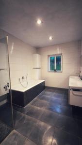 a large bathroom with a tub and a sink at Fietes Achternutkiek in Mellenthin +26 photos