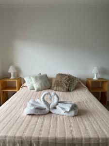 two swans towels are sitting on a bed at Cba Rent in Córdoba