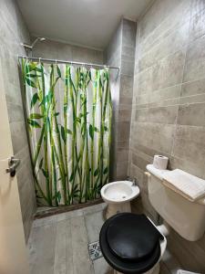 a bathroom with a toilet and a bamboo shower curtain at Cba Rent in Córdoba +20 photos