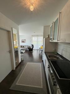 a kitchen with a sink and a living room at Schicke Ferienwohnung am Golfplatz in Bad Bellingen