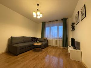 a living room with a couch and a television at Balvi center apartment in Balvi