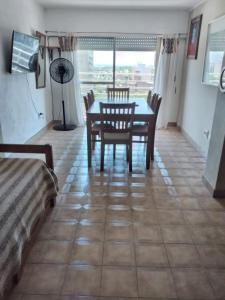 a dining room with a table and chairs on a tiled floor at Aires del Parque in Paraná