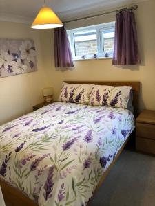 a bedroom with a bed with purple flowers on it at Seaclusion in St Austell