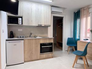a kitchen with wooden cabinets and a blue chair at Apartamento Kenia Tranquilo, acogedor y céntrico in Almansa