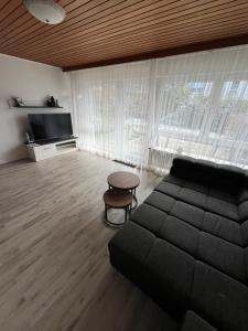 a living room with a couch and a tv at Reiheneckhaus mit Garten und Terasse in Tettnang