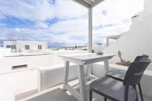 a white table and a chair on a balcony at ILIOS new 2bd house in Naousa in Naousa