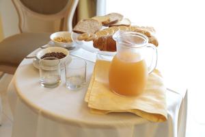 a table with a breakfast of bread and orange juice at Club Hotel Kennedy in Roccella Ionica
