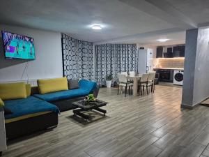 ein Wohnzimmer mit einem blauen Sofa und einem Tisch in der Unterkunft Casa ANDRADA in Horezu