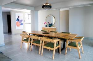 a dining room table with chairs and a mirror at Beach Front House - Back Up Power & Water in La Mercy