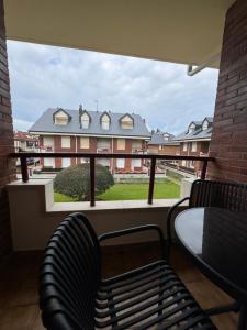 a balcony with a table and chairs and a building at Apartamento Aquí Mismo en playa de Somo Garaje in Somo