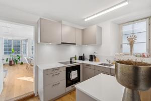 a kitchen with white cabinets and a large window at The R Apartment Cholfirst in Schaffhausen