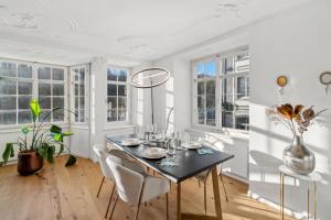 a dining room with a table and chairs and windows at The R Apartment Cholfirst in Schaffhausen