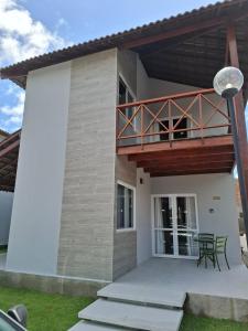 a house with a balcony with a deck at Praia dos Carneiros Condomínio Village in Tamandaré