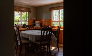 a dining room with a table and chairs and a kitchen at Villa La Romance Kreol in Rodrigues Island