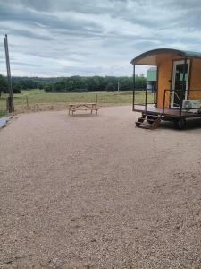 a picnic table next to a building with a bench at La Roulotte de Nanette in Druillat