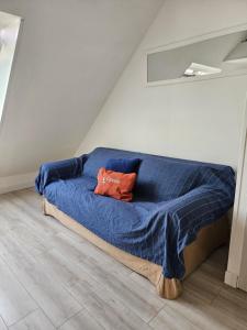 a bed with a blue comforter in a room at Studio neuf à proximité de Saint-Malo, à 2km des plus belles plages de la côte d'Emeraude in Saint-Coulomb