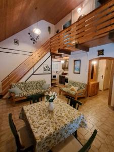 a living room with a table with a vase of flowers on it at Sunshine Vendégház Balatonfenyves in Balatonfenyves