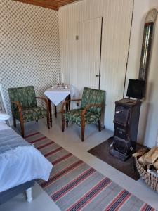 a room with a table and chairs and a stove at Skogsgläntan in Åshuvud