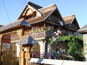 una casa con un balcón con flores. en Casa Muntean en Vadu Izei