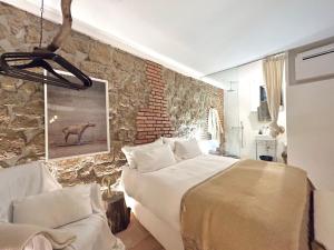 a bedroom with a large bed and a stone wall at Super Galleria - Borgo Stays in Tuscania