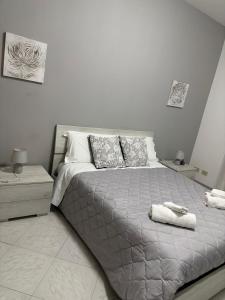 a bedroom with a bed with two towels on it at Montalbano House - Casa Vacanze in Santa Margherita di Belice