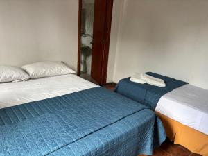 two beds sitting next to each other in a room at Apto. en Colonia, a 1 cuadra de la Plaza de Toros in Colonia del Sacramento