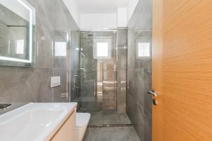 a bathroom with a shower and a sink and a toilet at Exclusive Seafront Apartments Apartment 3 in Vlorë +22 photos