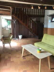 a living room with a green couch and a table at Pîgeonnier du Rau avec Parc et piscine 1-0 in Gamarde-les-Bains +16 photos