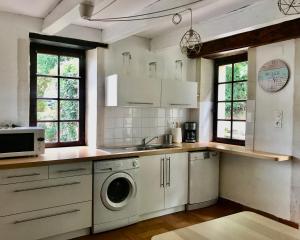 a kitchen with a washer and dryer in it at Pîgeonnier du Rau avec Parc et piscine 1-0 in Gamarde-les-Bains