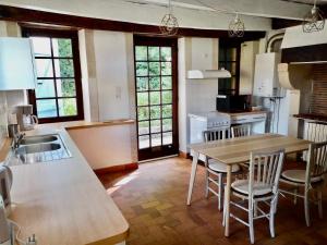 a kitchen with a table and chairs in a kitchen at Pîgeonnier du Rau avec Parc et piscine 1-0 in Gamarde-les-Bains