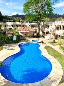 una gran piscina azul frente a algunos apartamentos en Sunscape Second Floor Condo With Rooftop, en Coco