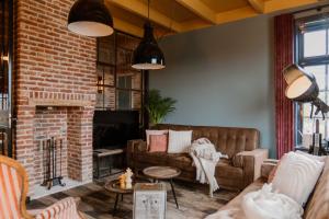 a living room with a couch and a brick wall at CRASH'NSTAY - Wachtpost 20 in Waspik