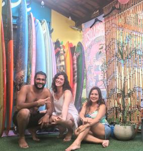 乌巴图巴Ubatuba Wild Surf Hostel的一群三人坐在冲浪板前