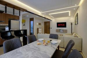 a dining room with a table and some chairs at Résidence privée Marrakech -Piscine-Parking in Marrakech +14 photos