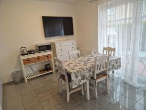 a dining room with a table and chairs and a television at Ferienwohnungen Saida Wohnung 3 in Norden +3 photos