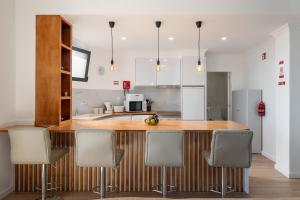 a kitchen with a wooden counter and chairs in it at Casa Jorge Calaça by An Island Apart in Caniçal +24 photos